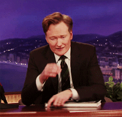 Conan O'Brien pinching the bridge of his nose and looking exasperated