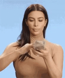 Kim Kardashian with a stack of bank notes, brushing the top ones off onto the floor