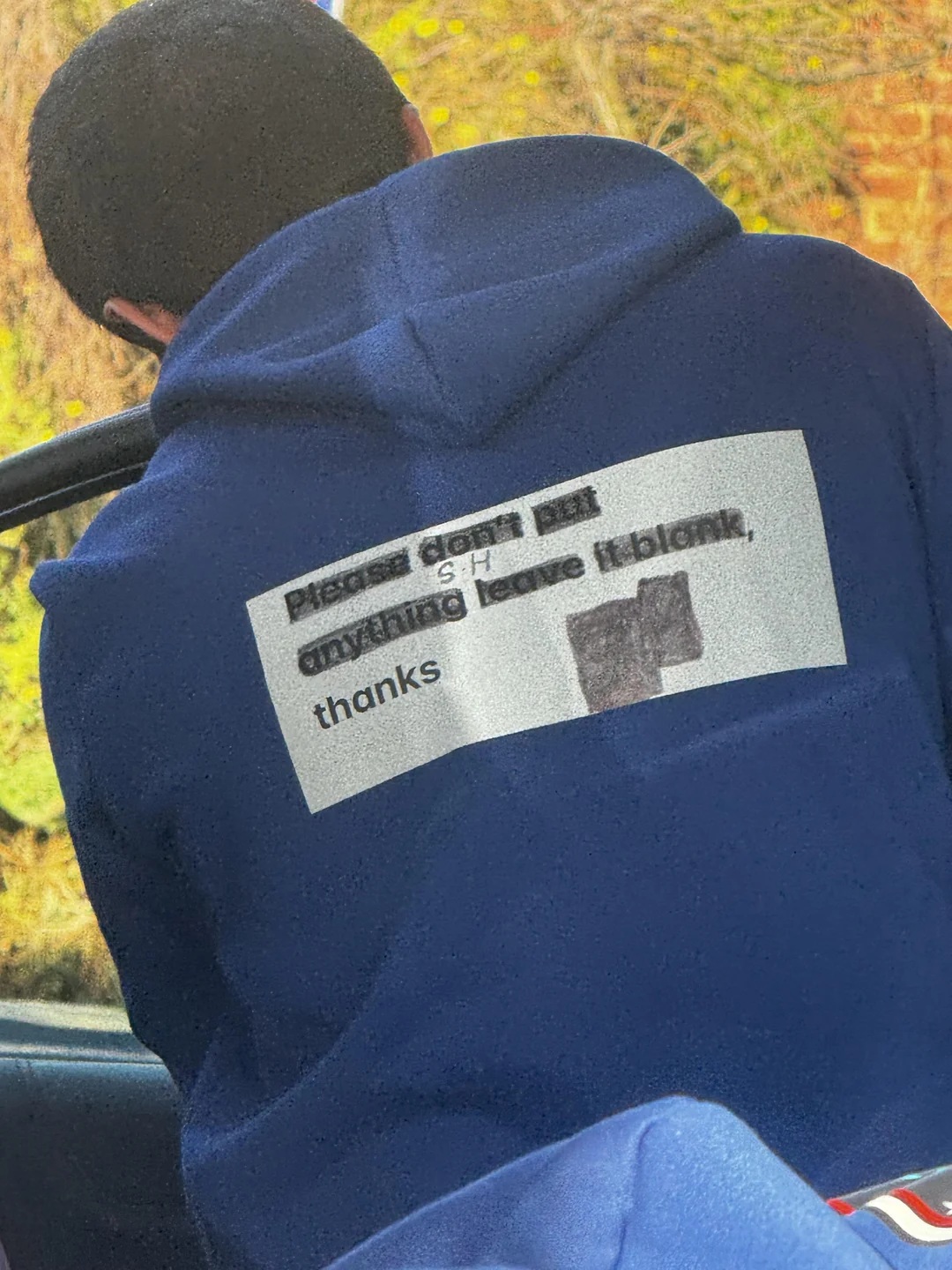 A man in a hoodie with 'Please don't put anything. Leave blank. Thanks' written on the back.
