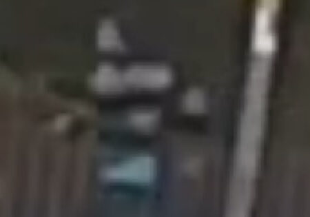 A blurry picture of a man running on a darkened street.