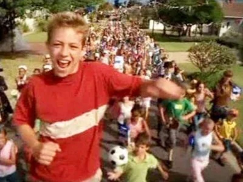 A still from the Frosties Advert where a boy is lifted over a running crowd in a cherry picker