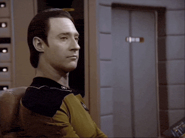 Data, the humanoid robot from Star Trek looking to his right, then looking away as though detecting something dubious.