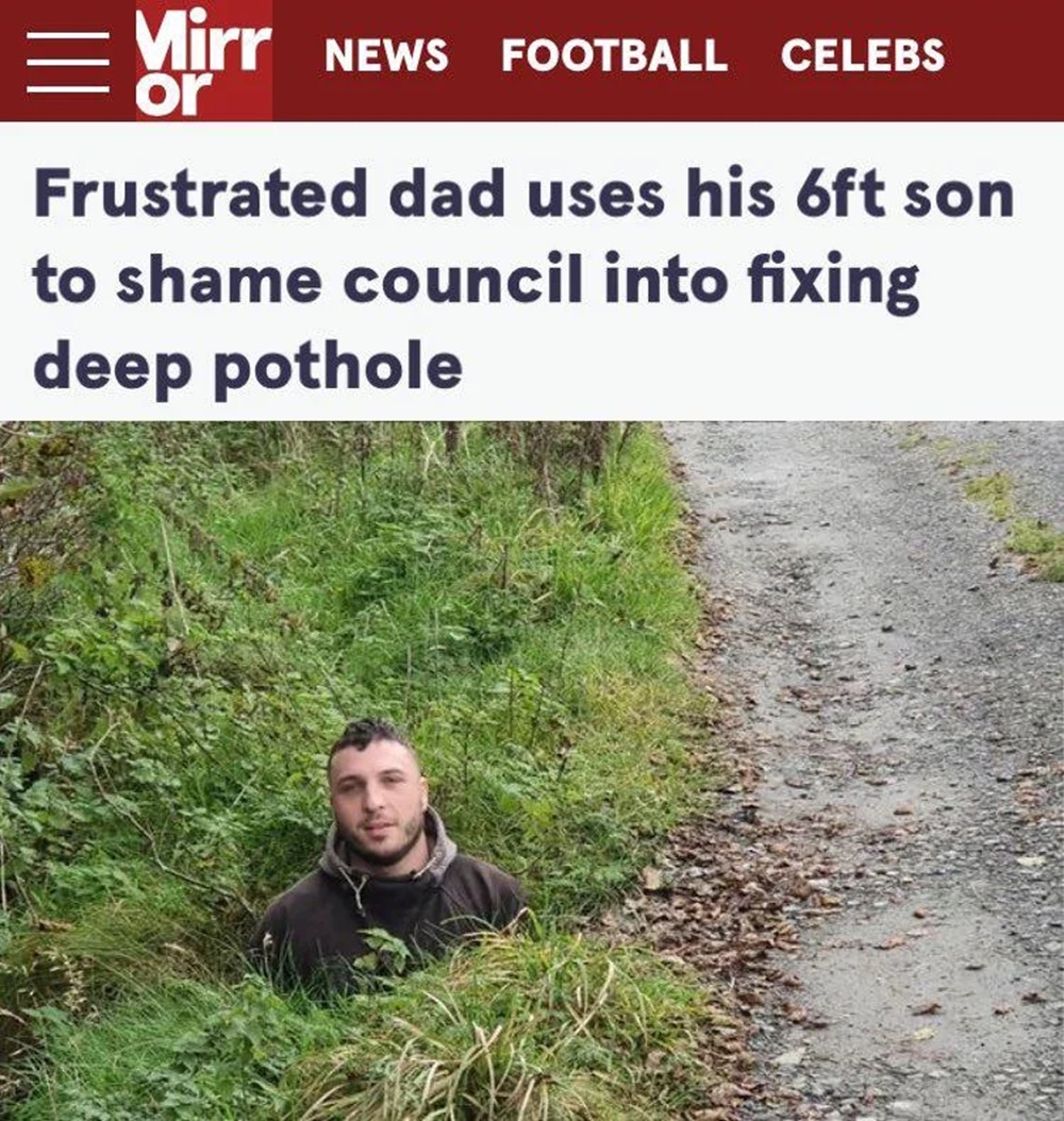 Headline -
Frustrated dad uses his 6ft son
to shame council into fixing
deep pothole
With an image of the head and shoulders of a man, sticking out of a pothole
