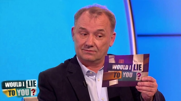 Bob Mortimer holing a Would I Lie to You card
