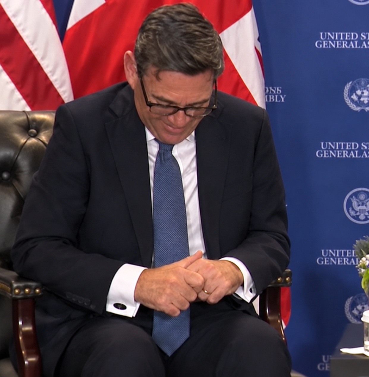 Andy Burnham with his head down, looking as tjough he's trying not to laugh.